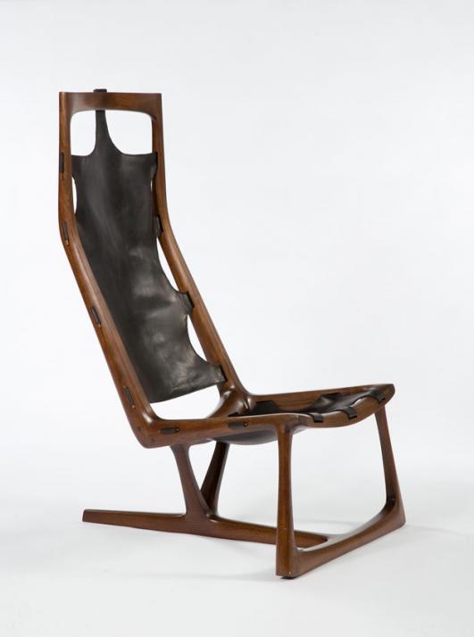 Early "Kangaroo" chair in hand-carved walnut and slung leather. Designed and made by Wendell Castle, Rochester, New York, 1962. Signed and dated, WC 62. One of the first three chairs produced by Wendell Castle.